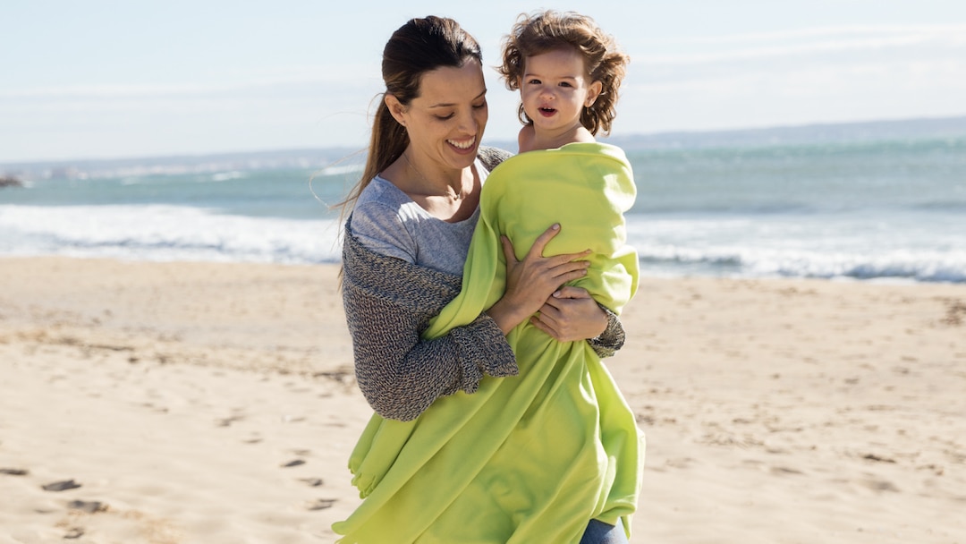 Mother with toddler on the beach.