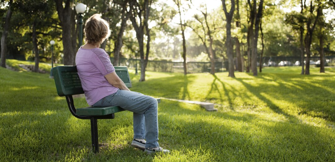 Lady Stiiing On The Bench In The Park