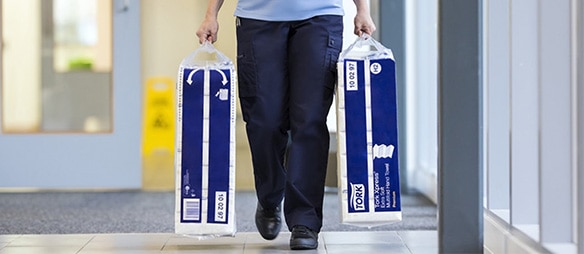 Personnel de nettoyage portant des emballages à deux mains