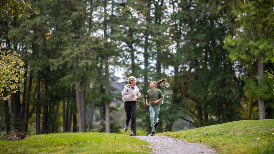 Mother And Daughter Running In Nature