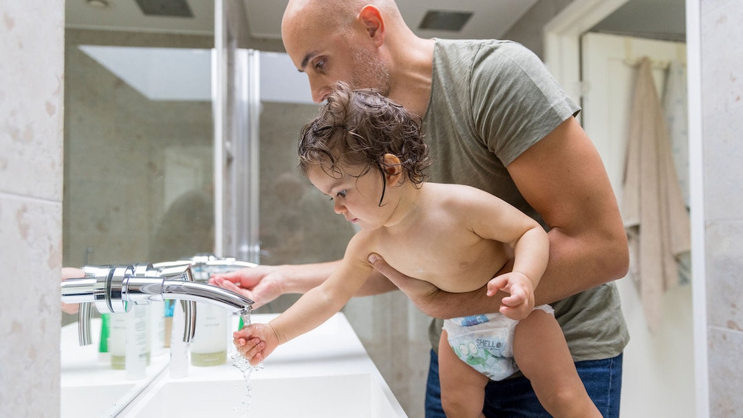 Father And Daughter In The Bathroom Washing Hands
